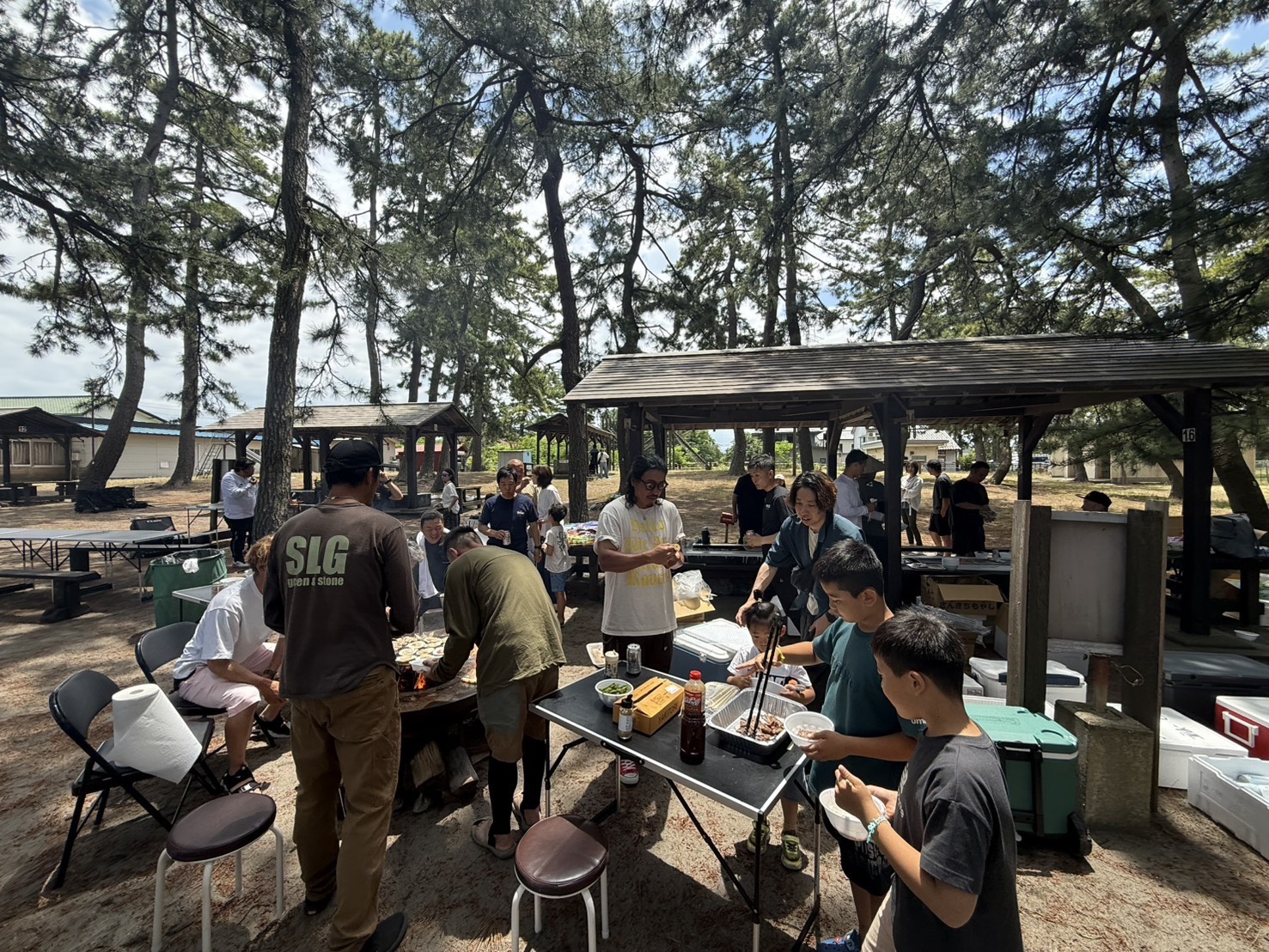 TKNの親睦BBQで焼き物を囲む参加者の様子